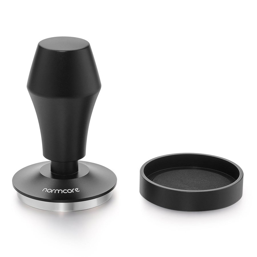 Normcore spring-loaded tamper V4 in black, beside its stand